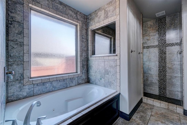 bathroom with tiled tub and plenty of natural light