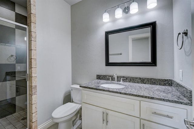 bathroom featuring tile patterned floors, a shower with door, vanity, and toilet