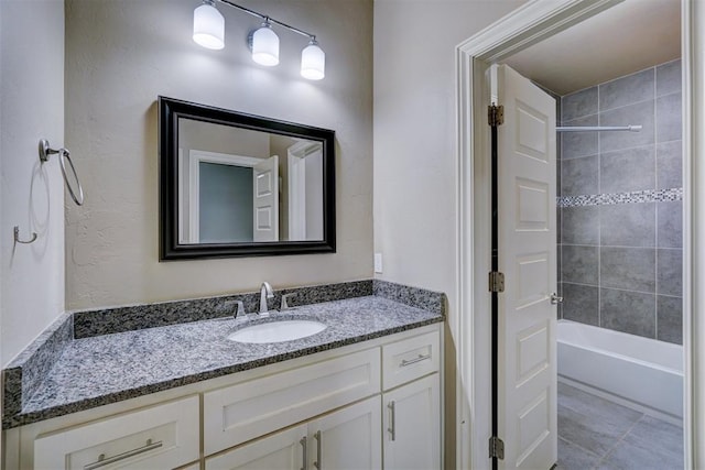 bathroom with tile patterned floors, vanity, and tiled shower / bath combo