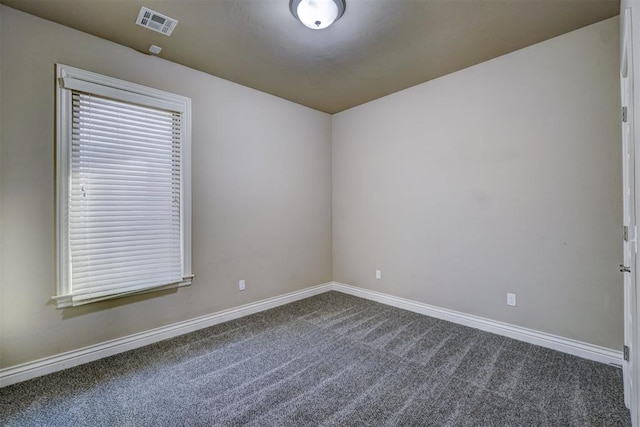 spare room with dark colored carpet