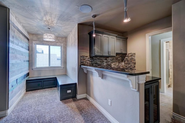 bar with beverage cooler, tasteful backsplash, a chandelier, pendant lighting, and light colored carpet