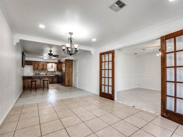 interior space featuring ceiling fan with notable chandelier, crown molding, and french doors