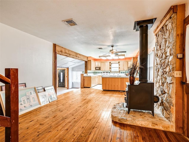 kitchen with light wood-type flooring, tasteful backsplash, and ceiling fan