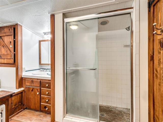 bathroom featuring hardwood / wood-style floors, vanity, and an enclosed shower