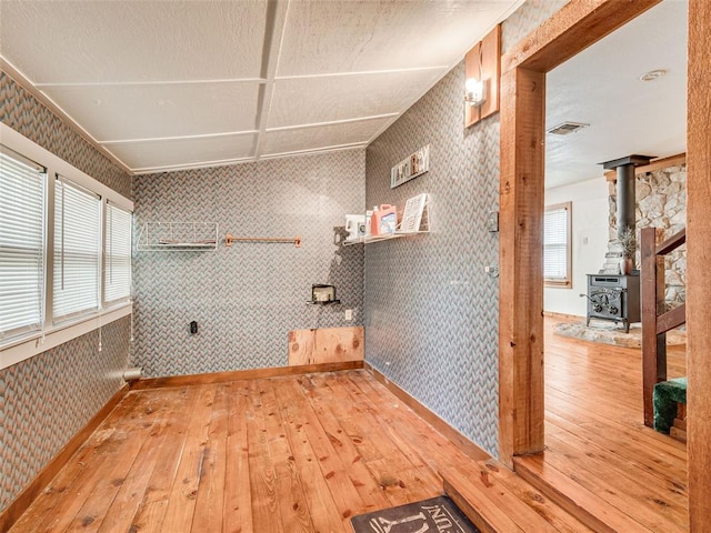 interior space with a wood stove and hardwood / wood-style floors