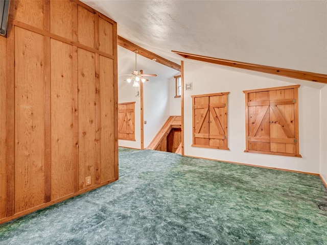 additional living space featuring carpet flooring, vaulted ceiling with beams, and ceiling fan