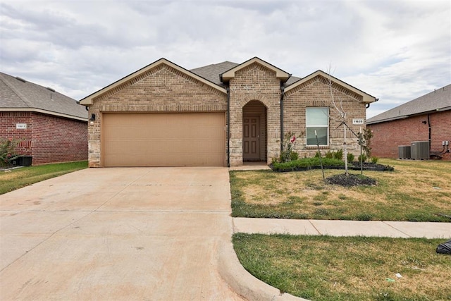 view of front of property with a front lawn, cooling unit, and a garage