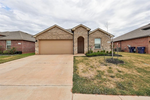 view of front of property featuring a front yard, a garage, and central AC unit