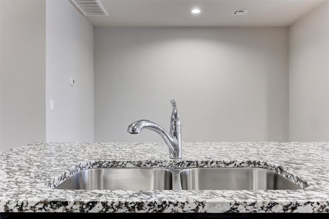 room details with light stone counters and sink