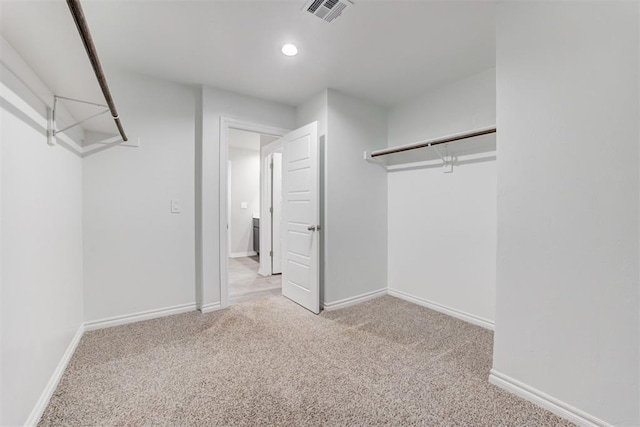 walk in closet featuring light colored carpet