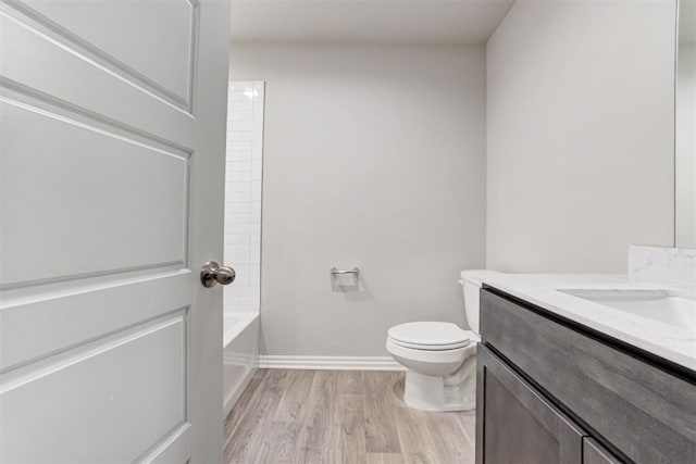 full bathroom with washtub / shower combination, wood-type flooring, vanity, and toilet