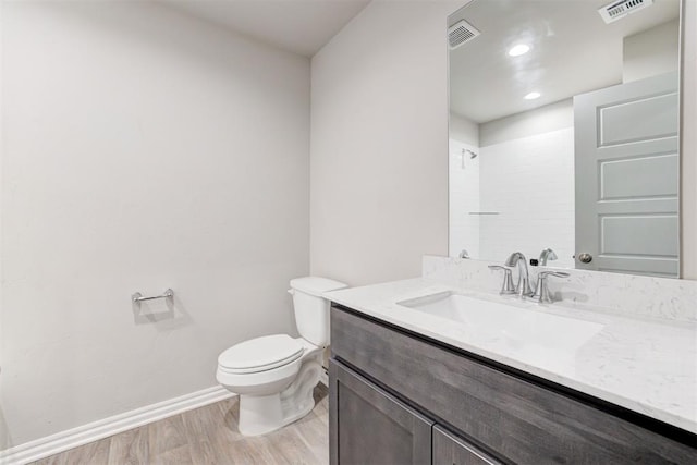 bathroom with walk in shower, toilet, vanity, and hardwood / wood-style flooring