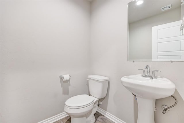 bathroom featuring sink, hardwood / wood-style floors, and toilet