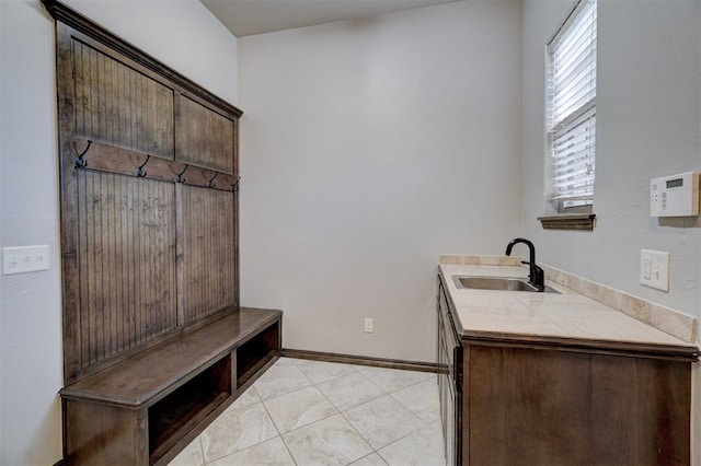 mudroom with sink and light tile patterned flooring