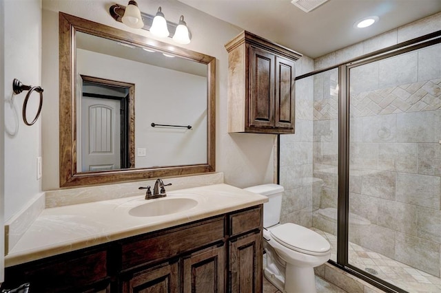 bathroom featuring vanity, toilet, and an enclosed shower