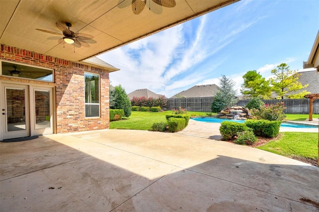 view of patio featuring a fenced in pool and ceiling fan