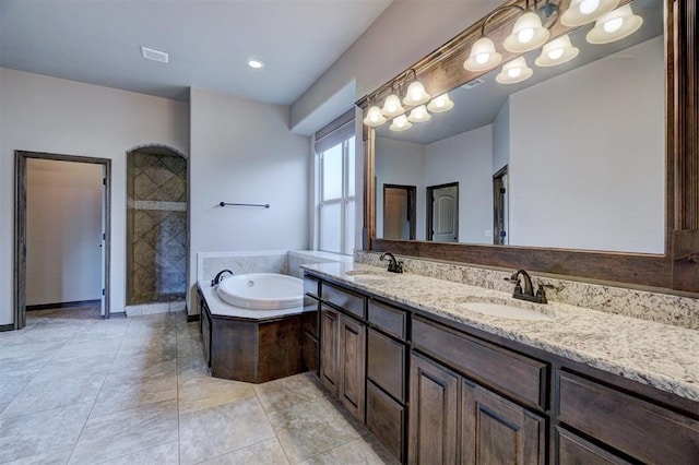 bathroom with tile patterned flooring, vanity, and shower with separate bathtub