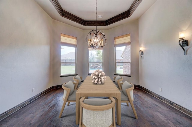 dining space with baseboards, a tray ceiling, dark wood-type flooring, and ornamental molding