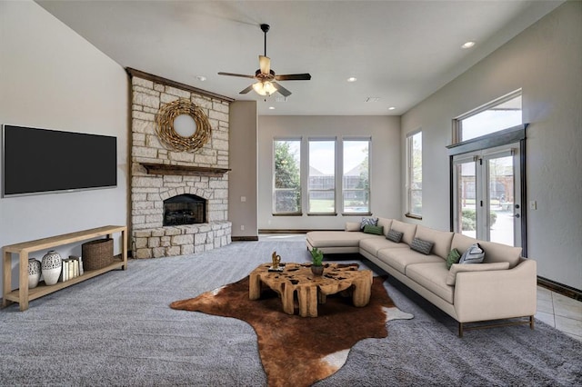 living room with recessed lighting, a healthy amount of sunlight, a stone fireplace, and baseboards