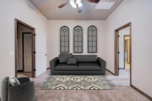 living room featuring baseboards, a ceiling fan, visible vents, and light colored carpet