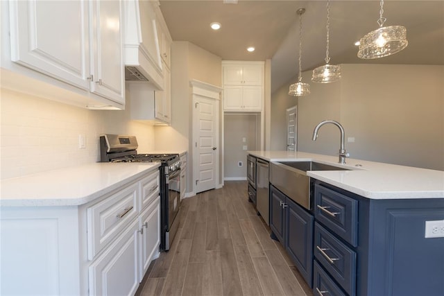 kitchen with pendant lighting, stainless steel appliances, white cabinetry, and blue cabinets