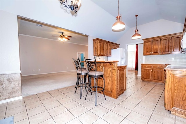 kitchen with pendant lighting, white appliances, lofted ceiling, light carpet, and ceiling fan with notable chandelier