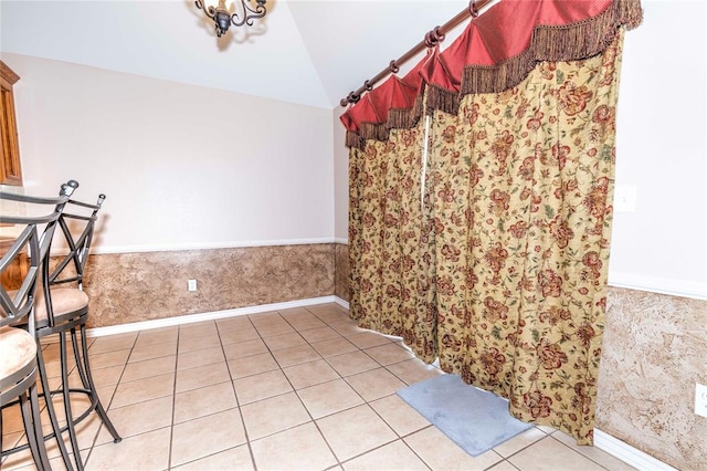 interior space with light tile patterned flooring and lofted ceiling