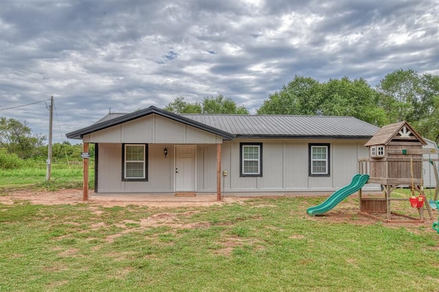 single story home featuring a front yard and a playground