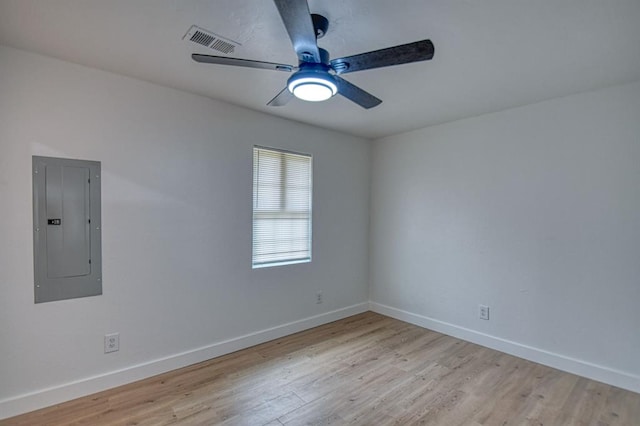 empty room featuring electric panel, ceiling fan, and light hardwood / wood-style floors