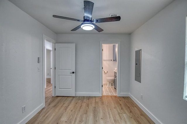 unfurnished bedroom featuring ensuite bath, ceiling fan, light hardwood / wood-style flooring, and electric panel