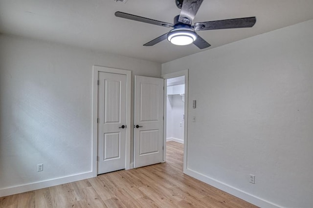 unfurnished bedroom with ceiling fan and light wood-type flooring