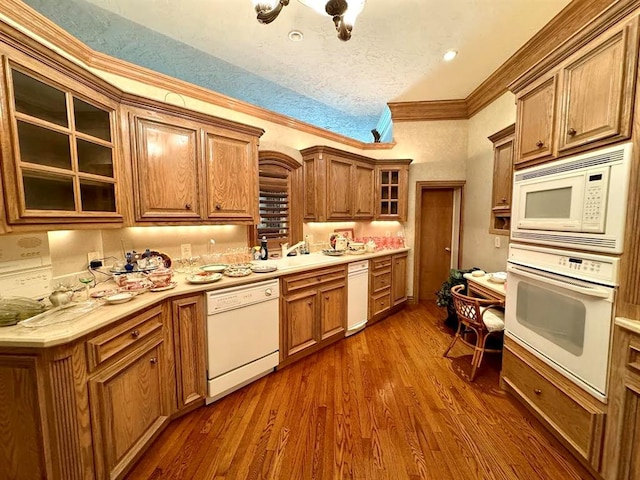 kitchen with a textured ceiling, dark hardwood / wood-style floors, white appliances, and crown molding