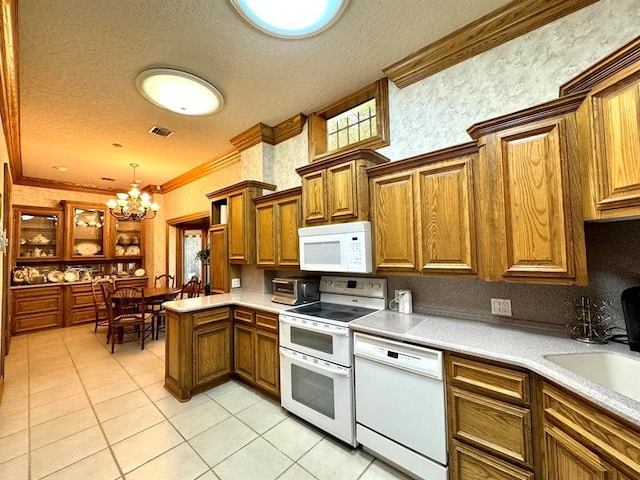 kitchen featuring pendant lighting, white appliances, an inviting chandelier, crown molding, and a textured ceiling