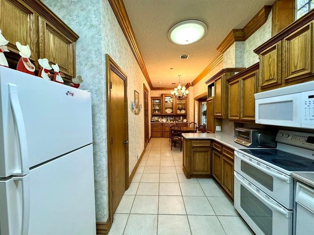 kitchen featuring crown molding, a chandelier, decorative light fixtures, white appliances, and light tile patterned floors