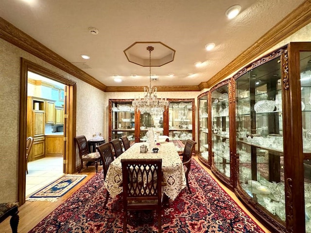 dining area featuring light hardwood / wood-style floors, a notable chandelier, and ornamental molding