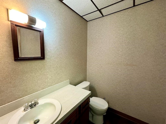 bathroom featuring vanity, a paneled ceiling, and toilet