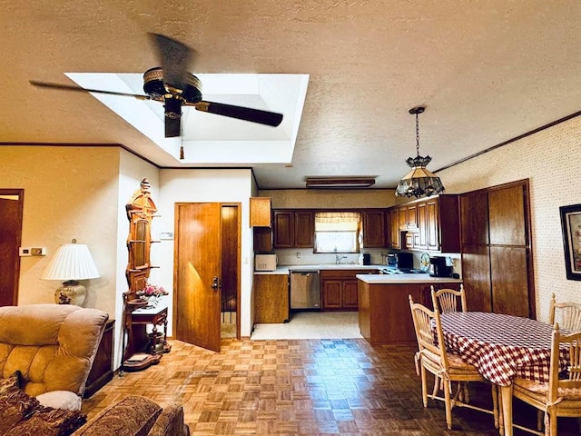 kitchen with appliances with stainless steel finishes, a textured ceiling, sink, pendant lighting, and light parquet flooring