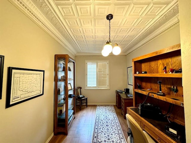 interior space with hardwood / wood-style flooring, crown molding, and a notable chandelier