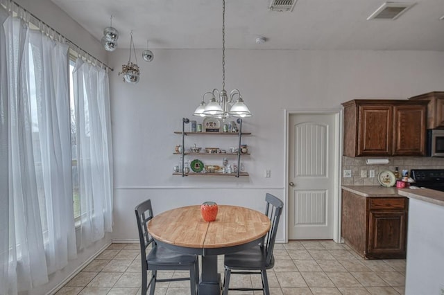 dining space featuring light tile patterned flooring and a chandelier