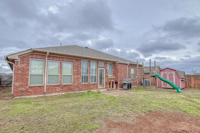 rear view of house featuring a patio area, a yard, central AC unit, and a shed