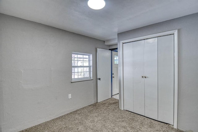 unfurnished bedroom featuring light carpet and a closet