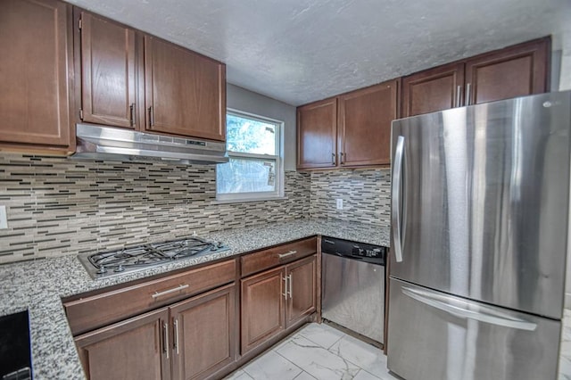 kitchen with decorative backsplash, light stone counters, and stainless steel appliances