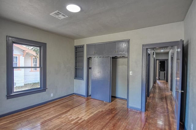 unfurnished bedroom with dark hardwood / wood-style flooring and a closet