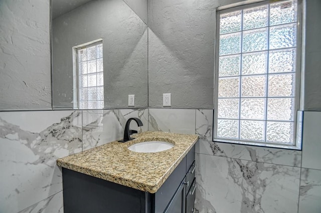 bathroom with vanity and tile walls