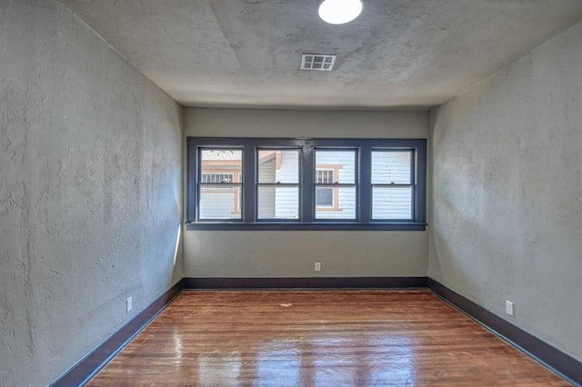 unfurnished room featuring hardwood / wood-style flooring