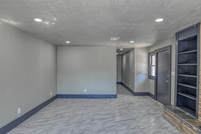 unfurnished room with a textured ceiling