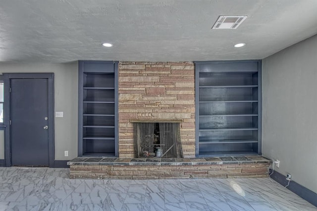 unfurnished living room featuring a stone fireplace, built in features, and a textured ceiling