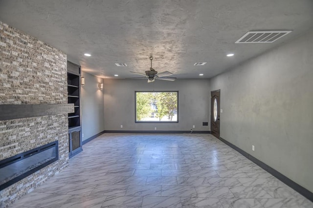 unfurnished living room with a stone fireplace, ceiling fan, and built in features