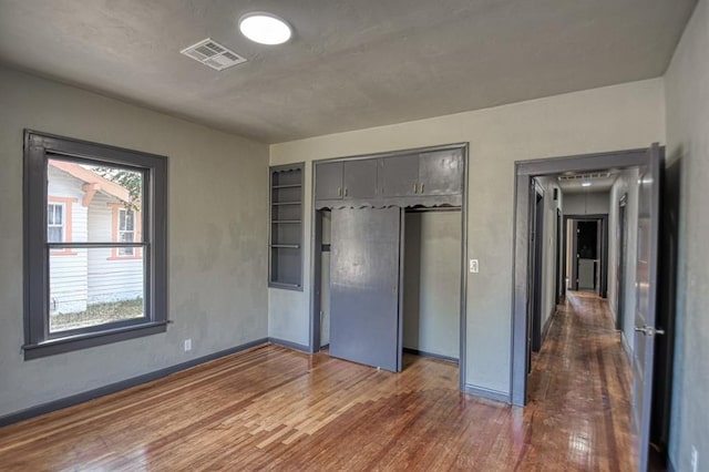 unfurnished bedroom with dark hardwood / wood-style flooring and a closet