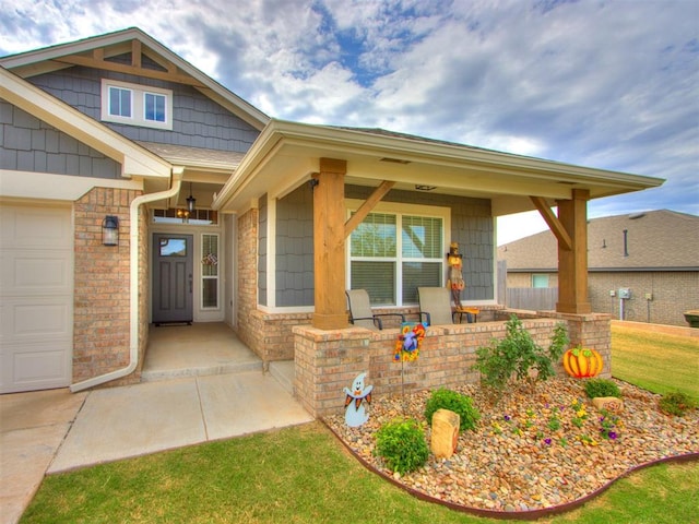 view of exterior entry with a porch and a garage